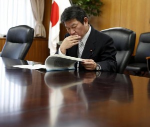 Japan's Economy, Trade and Industry Minister Motegi reads IAEA review report on TEPCO's tsunami-crippled Fukushima Daiichi nuclear power plant after he received it from Lentijo, head of review mission from IAEA in Tokyo